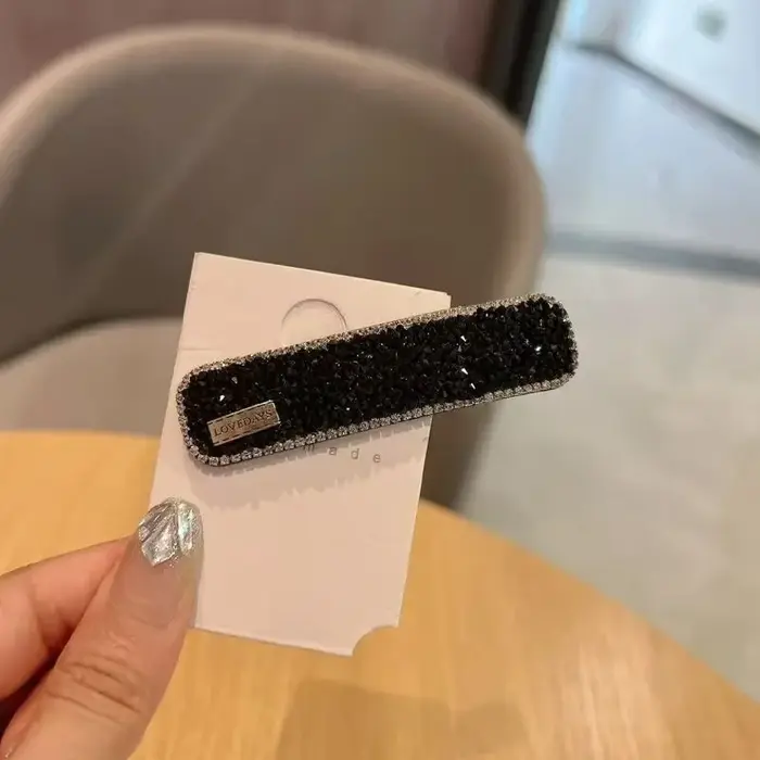 Pince à cheveux diamantée avec frange latérale et cheveux rebelles